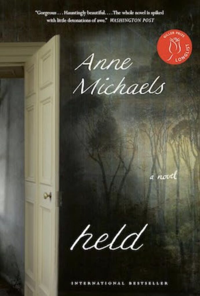 The image is the book cover for Held, a novel by Anne Michaels. কাহিনী
It features a moody, atmospheric scene dominated by a dimly lit interior: an open white wooden door (with a simple brass knob) stands ajar on the left, revealing a glimpse into a shadowy room. Beyond the threshold, the space transitions into a haunting, dreamlike outdoor landscape — a misty forest of tall, bare or sparsely leaved trees shrouded in fog or low light, evoking twilight or early dawn.
The overall color palette is subdued and ethereal: cool grays, deep greens, and muted browns for the woods, contrasted with the softer cream/white tones of the interior wall and door. The effect creates a powerful sense of liminality — standing between inside and outside, past and present, reality and memory — which beautifully mirrors the novel's themes of time, connection across generations, love persisting beyond death, and the blurred boundaries between life and the afterlife.
