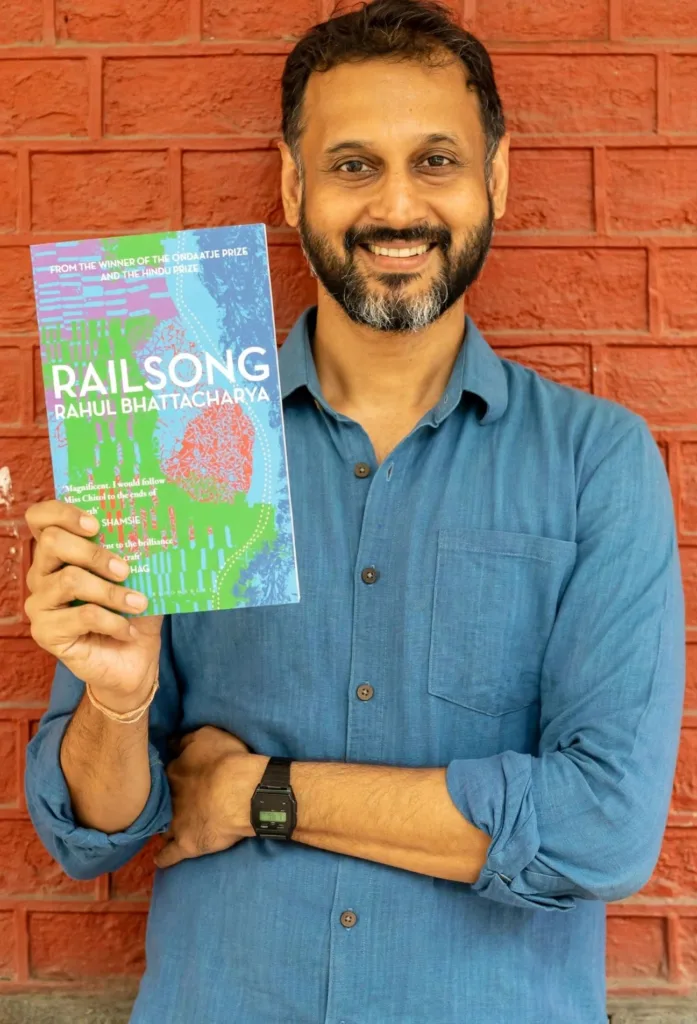 Writer Rahul Bhattacharya hold his new published book "rail song"in his right hand with a smiling face